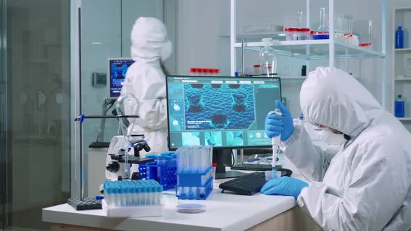 Scientist Wearing Coverall Examining Drug Discovery with Micropipette