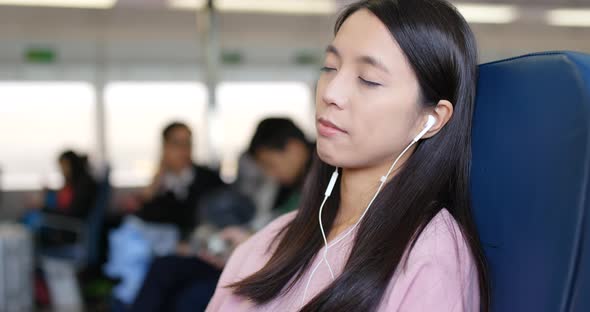 Woman using cellphone and listen to music on ferry