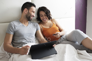 travel on line. Young hispanic couple using tablet and credit card for e-commerce and online purchase