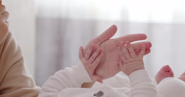 Pens Of Newborn Baby And Mother's Hands Close Up