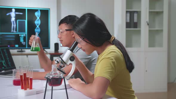 Boy And Girl Learning Science Experiment In Laboratory At Classroom. Study With Scientific Equipment alt