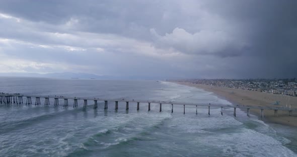 Storm clouds and waves by the Manhattan Beach Pier in California, AERIAL PAN
