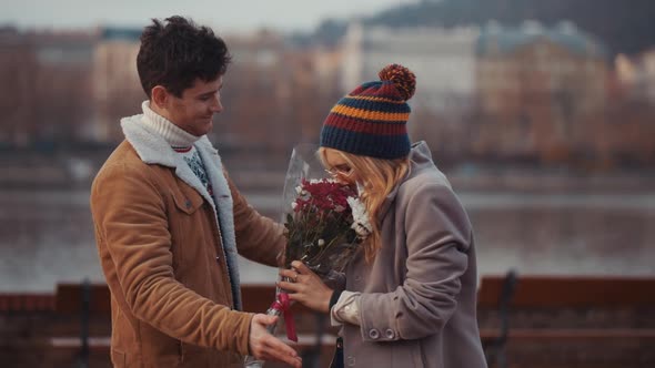 Young Man Giving Bloom Flower Bouquet to Woman on Valentine Day First Date