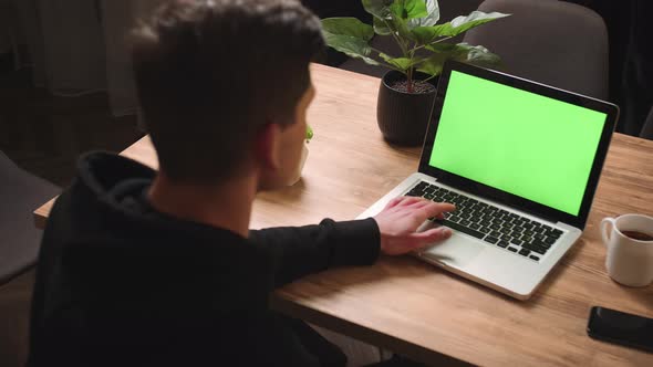 Back View of Man Waving Hand on Camera Laptop Green Screen Chromakey Man Has Video Call Chatting on