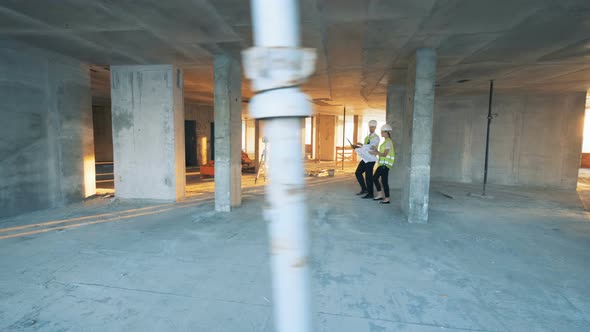 Engineers Walk Through a Building on a Construction Site.