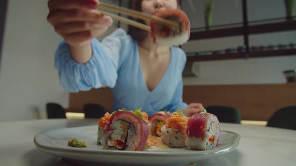 Beautiful Asian Female Enjoying Taste of Delicious Sushi Rolls