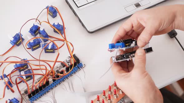 Male Programmer Creates Robotics an Arduino Board Controls Servo Motors