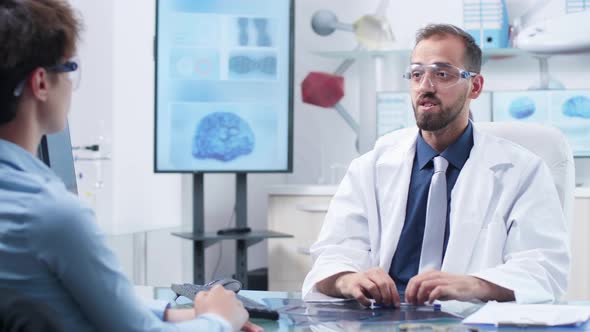 Physician Wearing Augmented Reality Glasses Showing Something To a Patient