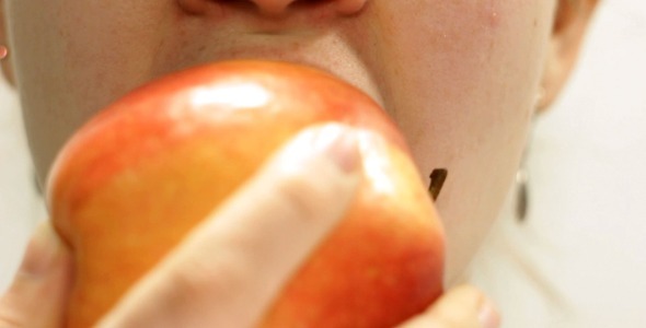 Female Biting A Ripe Apple Closeup