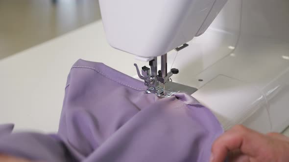 Seamstress Works at Sewing Machine Makes Straight Seams on Cloth Hands Closeup