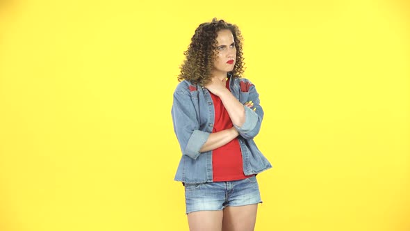 Lovely Girl Is Very Offended and Looks Away on Yellow Background at Studio