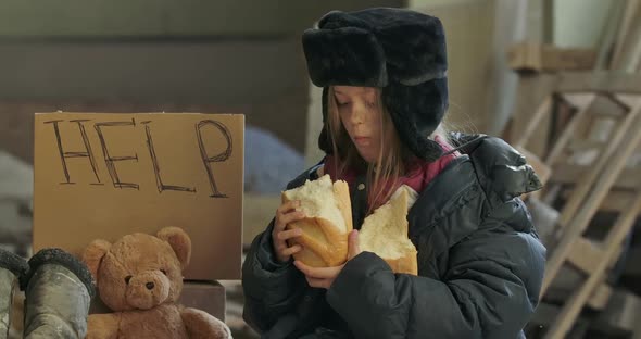 Portrait of Ukrainian Refugee with Dirty Face Eating Greedily the Loaf of Bread