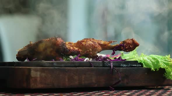 Close-Up Roasted Chicken BBQ Leg Piece on Round Table With Smoke in Beautifull Background.