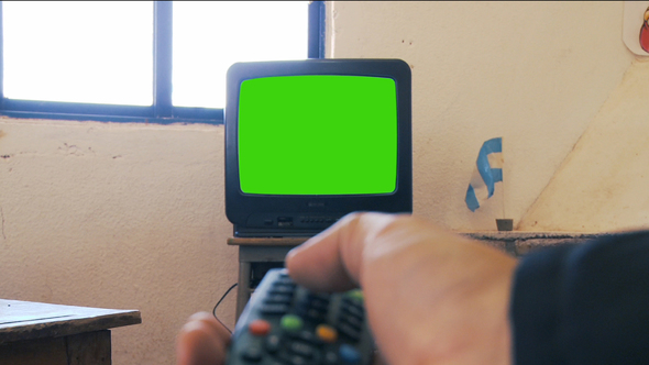 Hand Pointing the Remote Control at Television Green Screen.