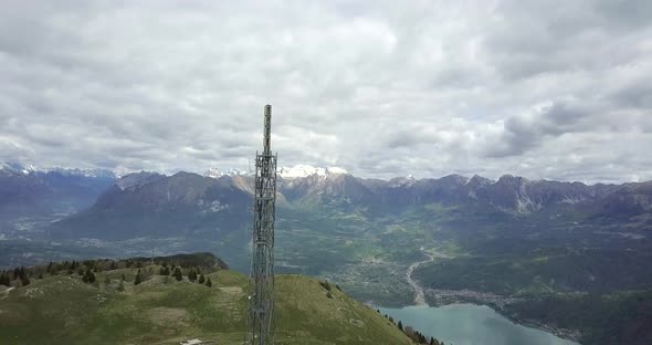 Aerial drone view of radio antenna cellular tower at the top of a hill.