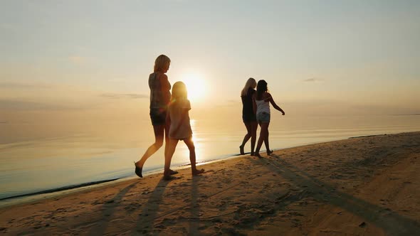 Parents with Children Walk in the Sand on the Beach.