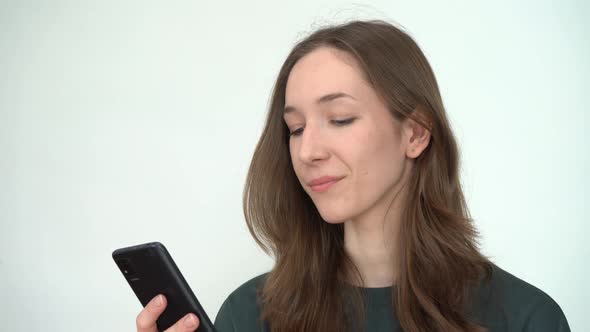 A Young Woman Emotionally Reading Messages on Her Smartphone