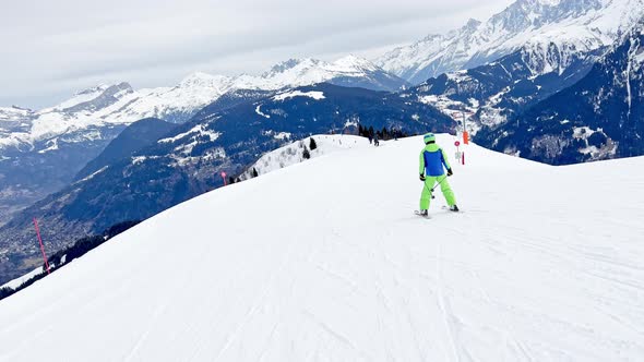 Boy Ski Downhill on Top of the Mountain Over Alps