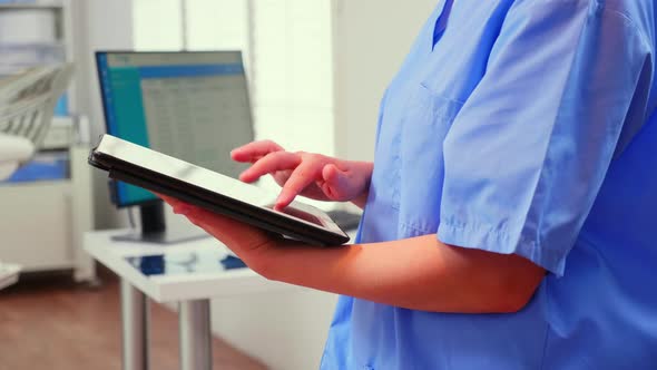 Close Up of Assistant Holding Tablet and Analysing Teeth Xray