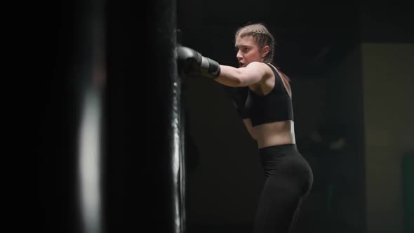 Female Fighter Trains His Punches Beats a Punching Bag Kickboxing Training Day in the Boxing Gym