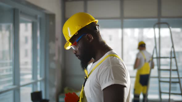 Tired African American Construction Worker Drinking Water