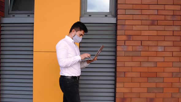 Businessman Uses Laptop While Walking