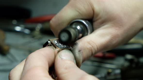 Hands of the Jeweler Polishes Ring on the Polishing Machine