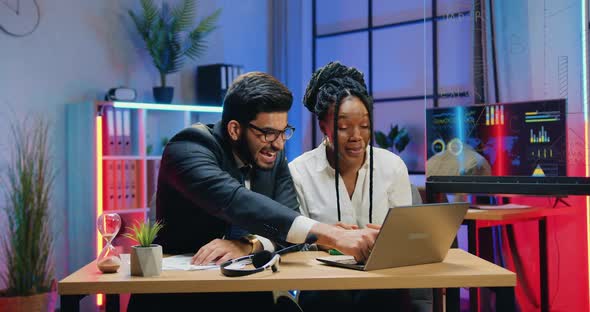 Male and Female Office Workers Sitting at Workplace and Looking on Laptop Screen, Getting Good News