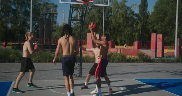 Sportsmen Play Basketball and Score Ball Into Backboard Hoop