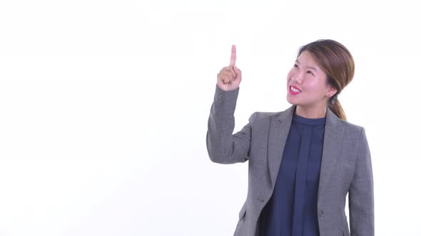 Happy Young Asian Businesswoman Talking While Pointing Up