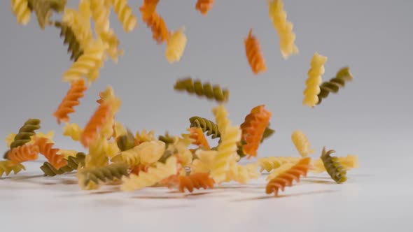 Pasta falling onto a white surface in slow motion