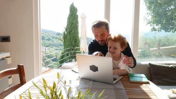 Father and son using laptop at home