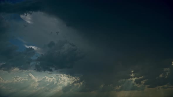 Sun Rays Shining Through Dark Storm Cloudy Rainy Sky With Fluffy Rain Clouds alt
