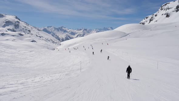 A Lot Of Skiers Roll Down The Snowy Ski Track In Winter In The Mountains