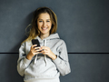 Smiling young woman with her cellphone - PhotoDune Item for Sale