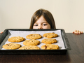 Young girl looking at a tray of fresh baked cookies - PhotoDune Item for Sale