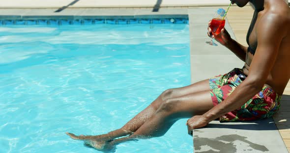 Low section of black man drinking cocktail drink near swimming pool 4k