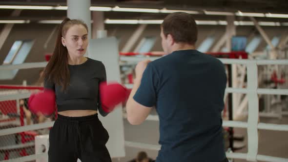 Boxing Training  an Attractive Woman Having a Training with a Boxing Coach  Learning How To Defense