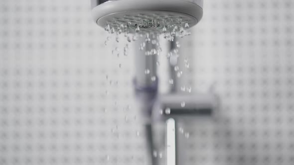 Close-Up of Turning on the Shower Head in Bathroom Water Sprays Out Flow Slowly in Front of Camera