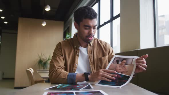 Mixed race businessman having a video chat going through paperwork modern office