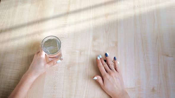 POV Shot Female Hands Tablet Pills with Glass of Water Applying Medical Cure