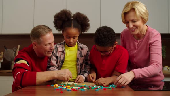 Cheerful Grandparents and Multicultural Kids Playing Sorting Puzzle Game