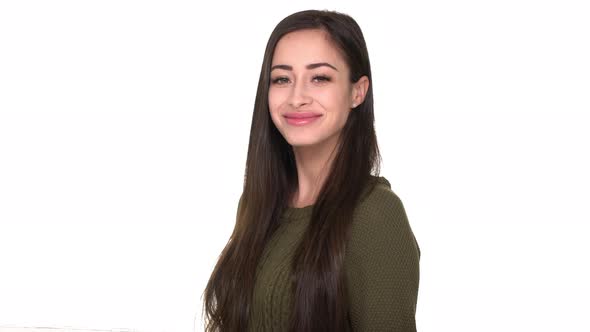 Halfturned Portrait of Friendly Adult Woman Looking at Camera with Smile Showing Thumb Up Meaning