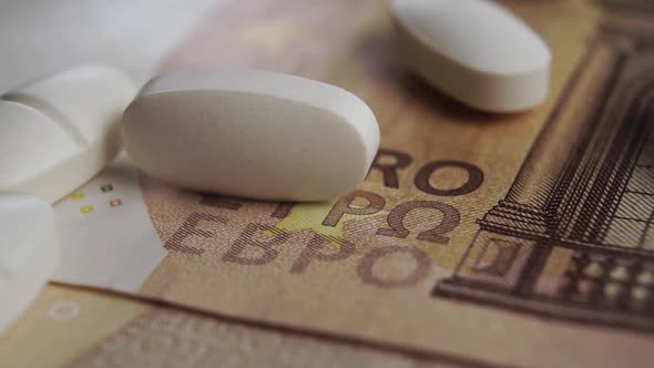 Medical pills are scattered on Euro bills