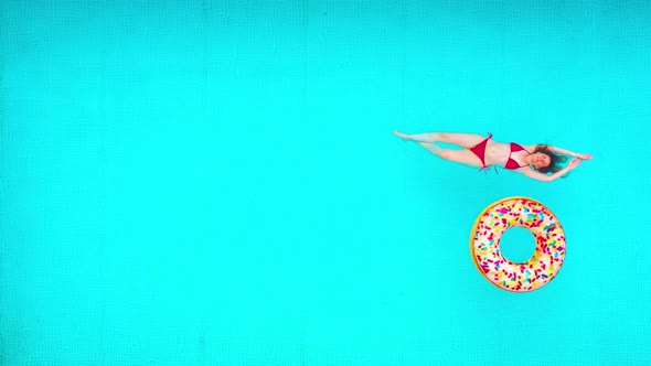 View From the Top As a Woman in a Red Swimsuit Lying on Her Back in the Pool