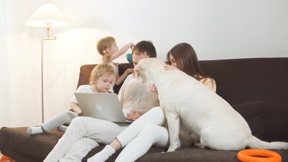 Friendly Caucasian Family at Home with Laptop