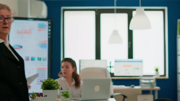 Successful Senior Entrepreneur Standing in Front of Meeting Desk Looking at Camera