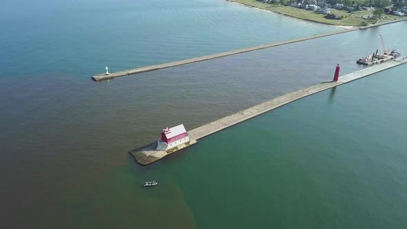 Aerial view of beacon/lighthouse on pier in Michigan, USA. Drone moves slowly downward toward lighth