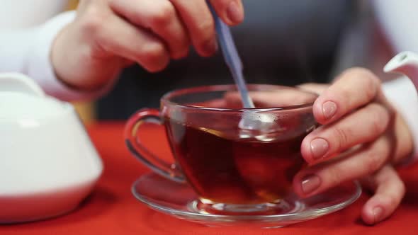 Person Having a Break. Woman Stirring Sugar in the Cup. Relaxed Human at Work