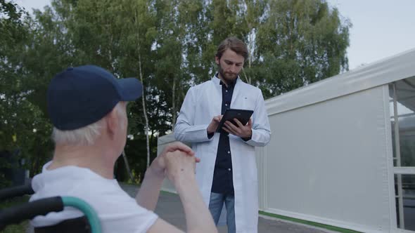 Doctor Whites Something on His Black Tablet